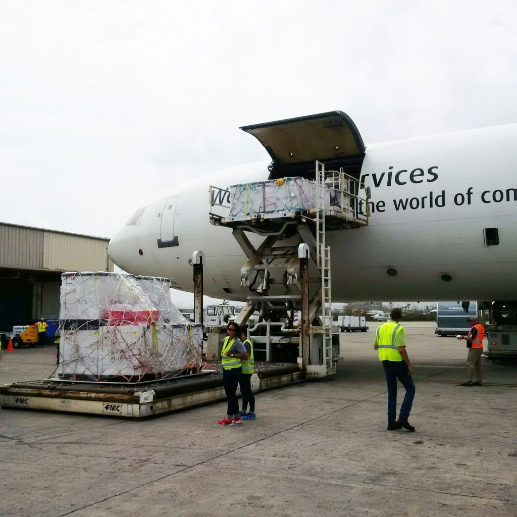 Ground crew loading palletised cargo into a freighter aircraft